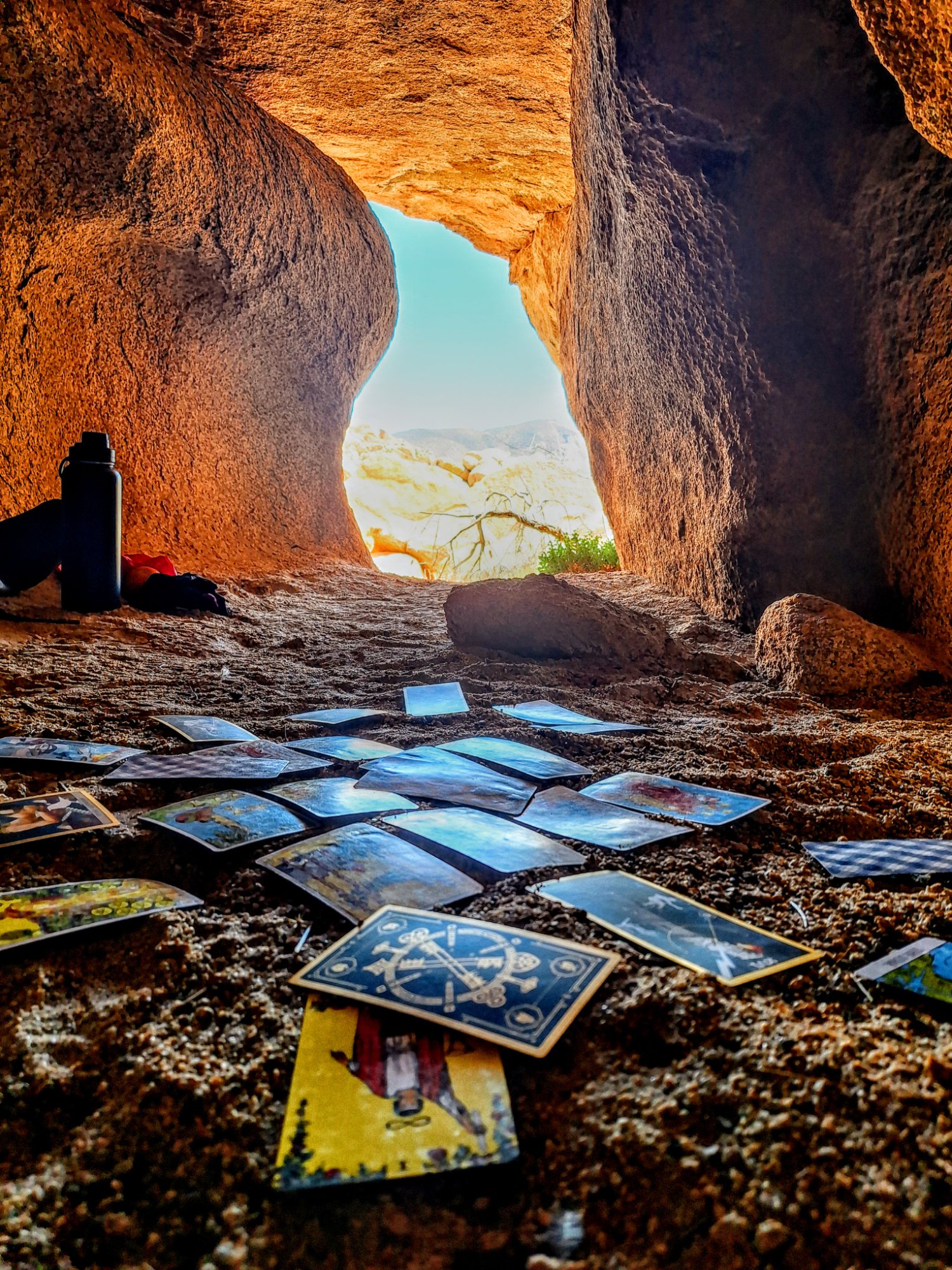 Tarot cards spread across the floor of a cave in Joshua Tree