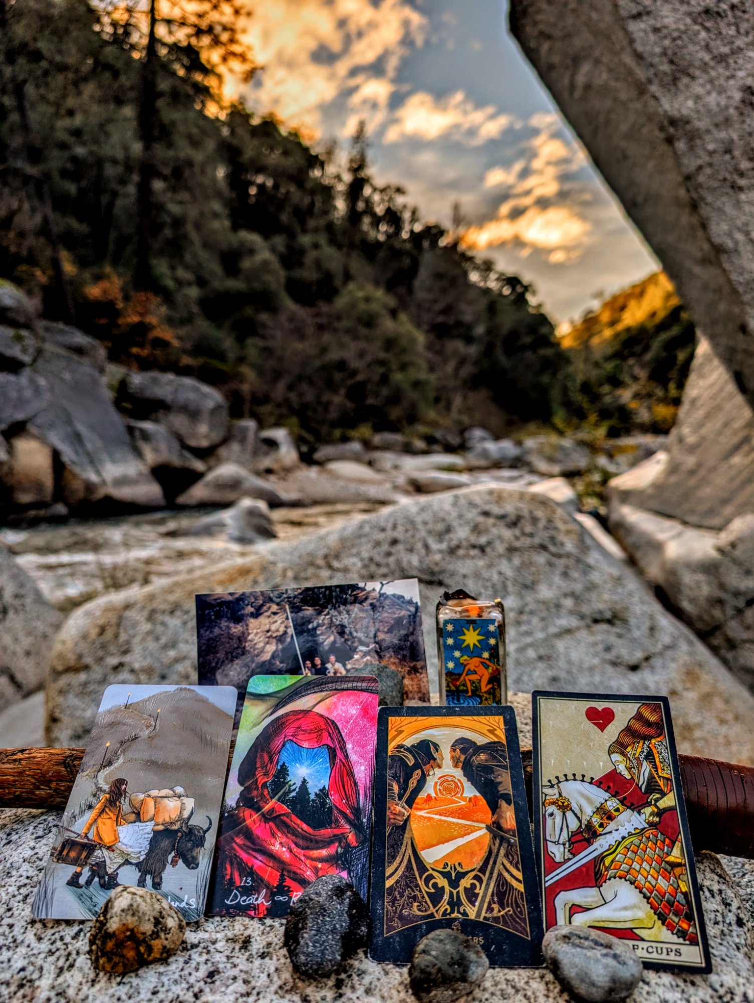 Tarot cards on boulders at the Yuba River at dusk